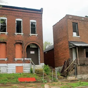 Photo of two two-story dilapidated brick buildings.